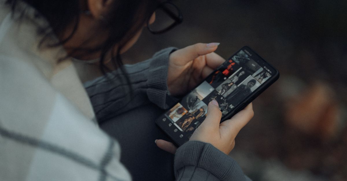 Persona che guarda con sollievo le foto ritrovate sullo schermo dello smartphone