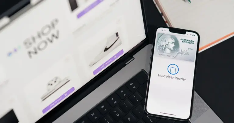 Smartphone con app di pagamento accanto a un laptop per acquisti online