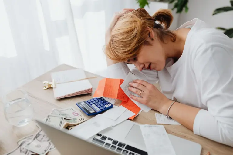 Donna che gestisce le finanze di casa con calcolatrice, contanti e ricevute
