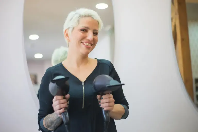 Estetista sorridente con strumenti da lavoro in un salone moderno