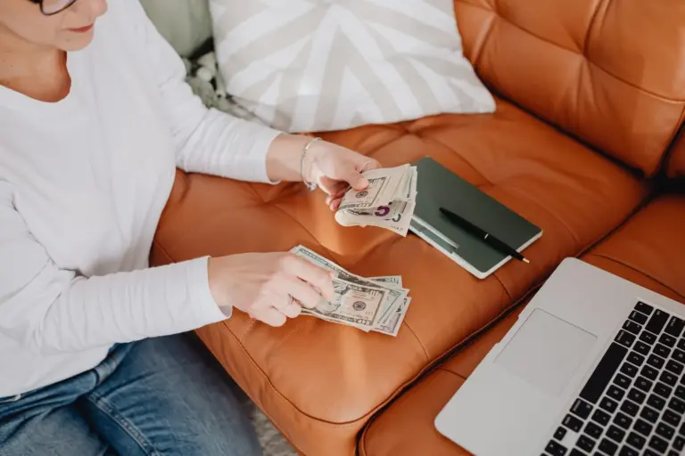 Donna che pianifica il budget familiare con laptop e appunti sul divano