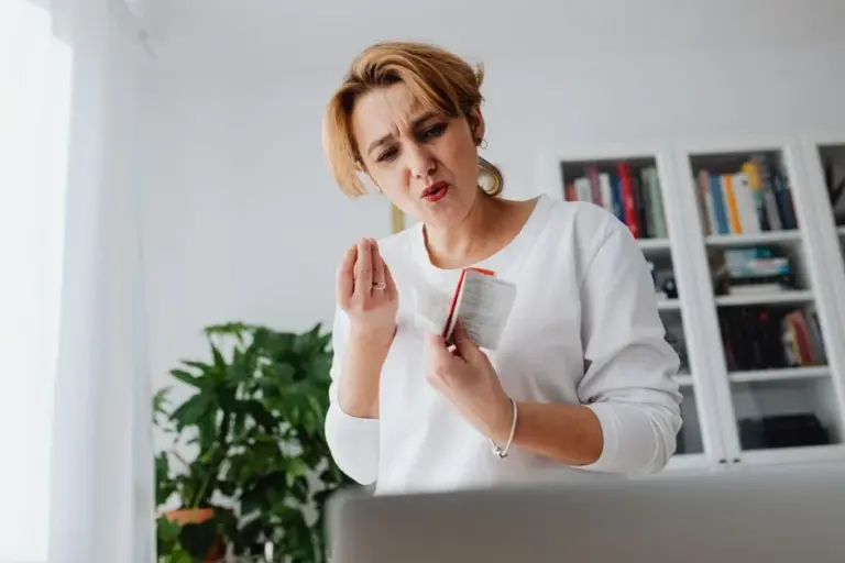 Donna preoccupata che controlla le proprie finanze con ricevute in mano