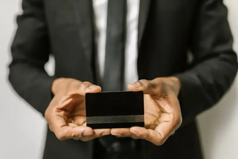 Uomo d'affari che tiene in mano una carta di credito bianca