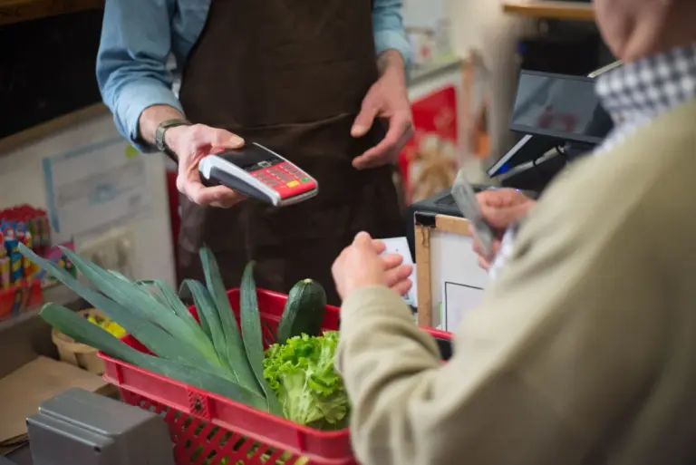 Cliente che paga alla cassa del supermercato con la carta
