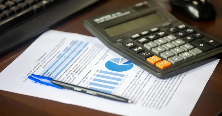 Scrivania con calcolatrice e report finanziario per un confronto