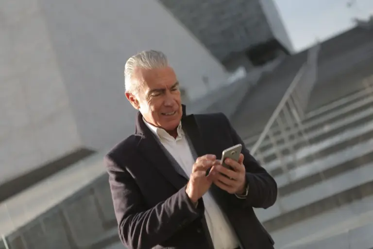Uomo anziano che usa lo smartphone per operazioni bancarie