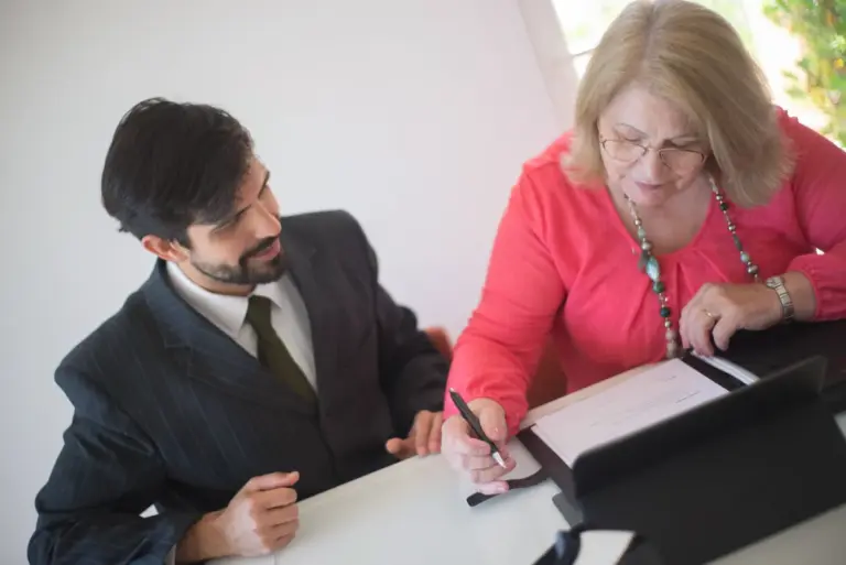 Donna anziana che firma un documento contrattuale