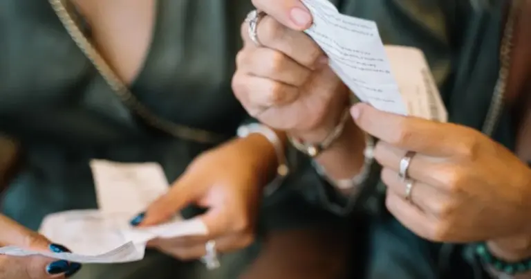 Due mani che confrontano scontrini e carte fedeltà su un tavolo