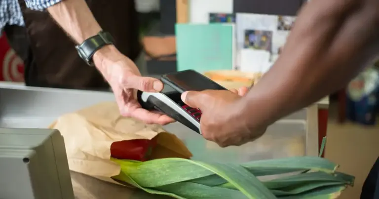 Persona che paga con lo smartphone alla cassa del supermercato