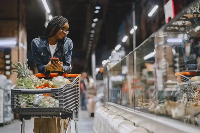 Donna che fa la spesa al supermercato con il carrello