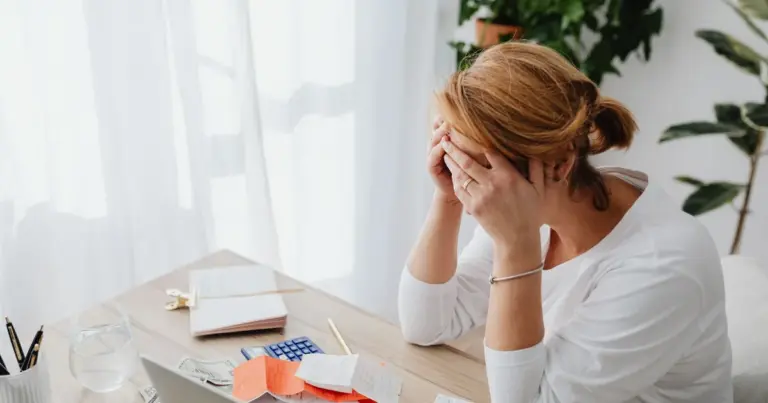 Donna preoccupata tra ricevute e conti a una scrivania