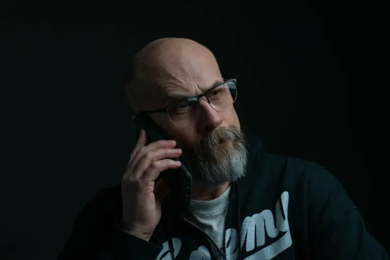 Uomo anziano al telefono con espressione seria