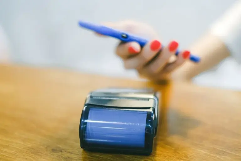 Mano che usa lo smartphone per un pagamento contactless su un terminale