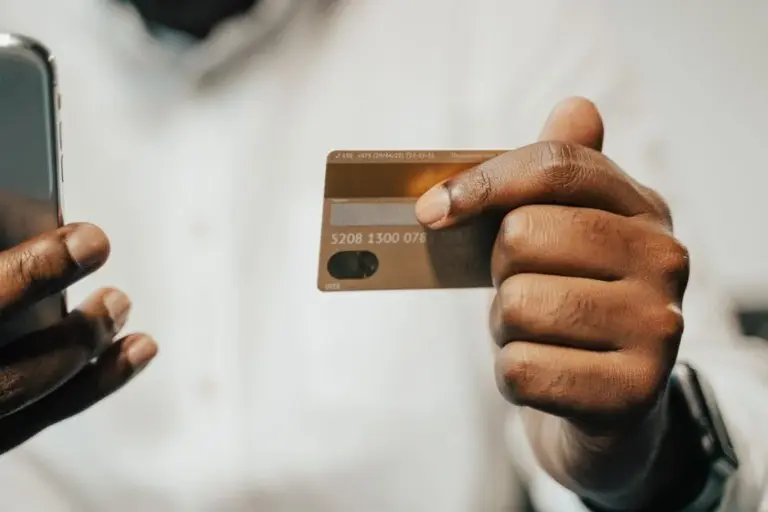 Mano che mostra una carta vicino al telefono